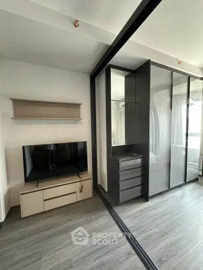 Modern bedroom with sleek wardrobe and mounted TV unit