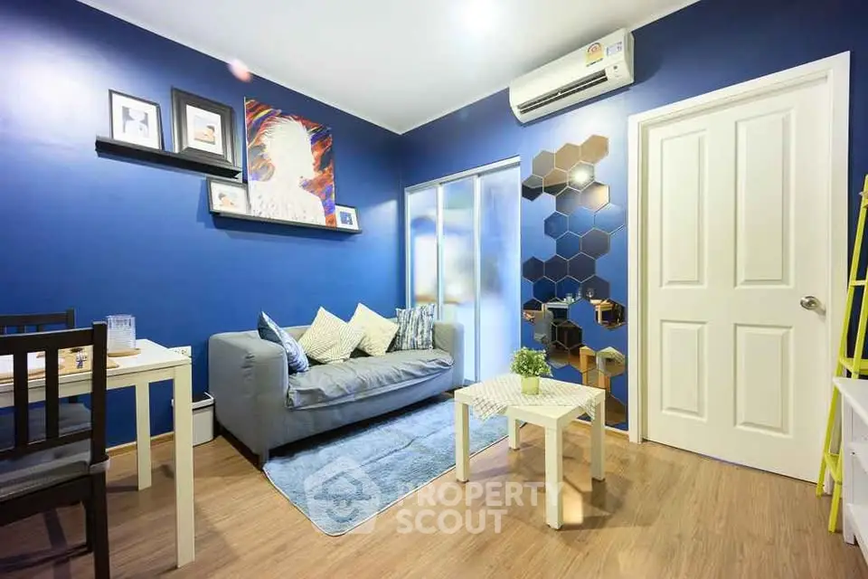 Chic modern living room with blue walls, cozy sofa, and stylish decor in a contemporary apartment.