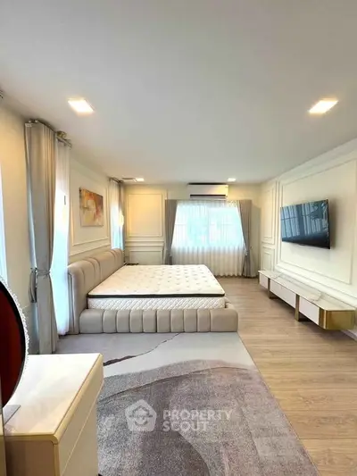 Luxurious bedroom with modern decor, large bed, and wall-mounted TV in elegant apartment.