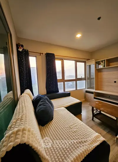 Cozy living room with large windows and comfortable seating, perfect for relaxation.