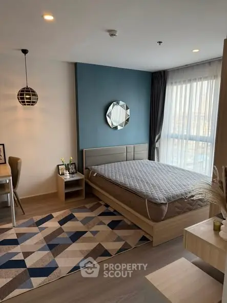 Modern bedroom with stylish decor and large window offering natural light.