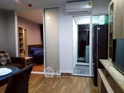 Modern apartment interior with open layout, featuring living room, bedroom, and kitchen with sleek appliances.