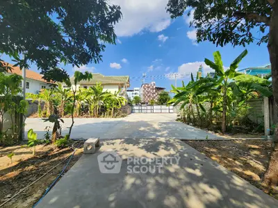 Spacious garden area with lush greenery and clear blue sky, perfect for outdoor activities.