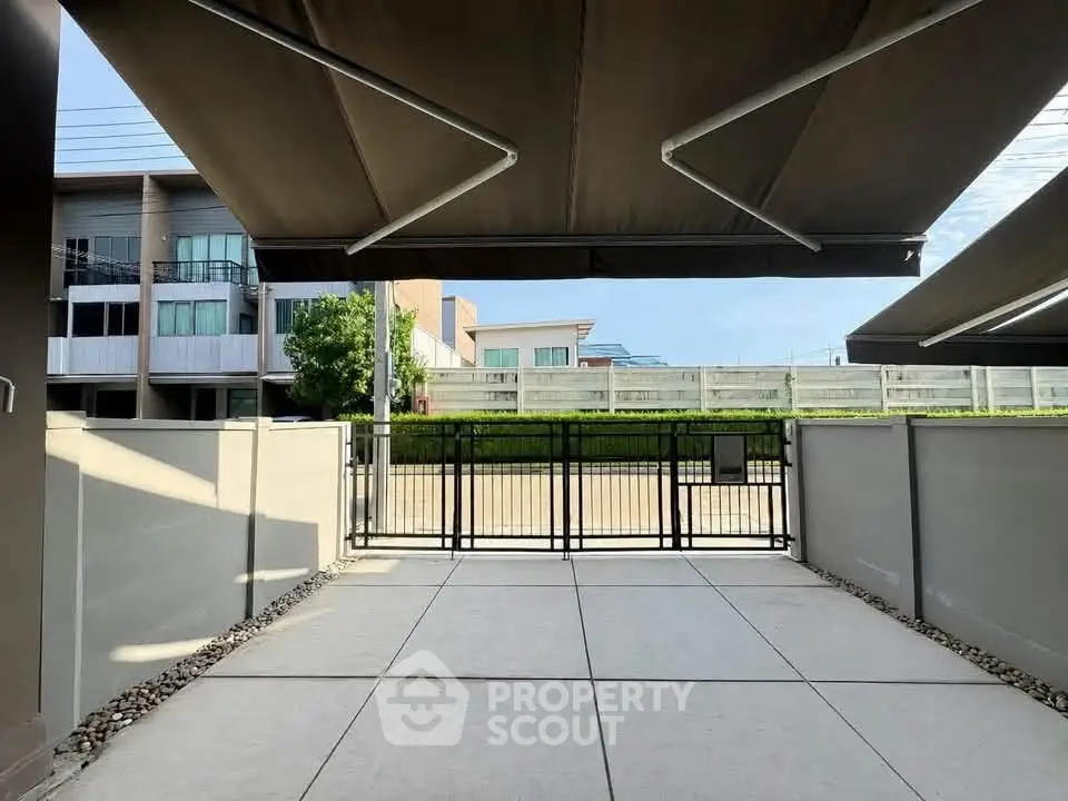 Spacious outdoor patio with modern awnings in a contemporary residential complex.