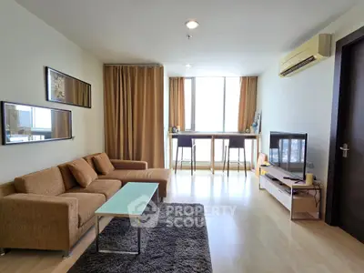 Modern living room with cozy sofa, stylish decor, and natural light from large windows.