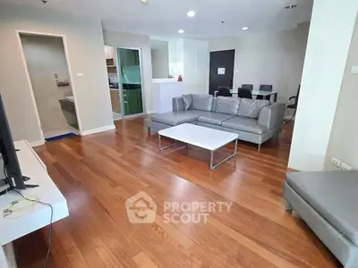 Spacious modern living room with wooden flooring and sleek furniture in a contemporary apartment.