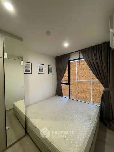Cozy bedroom with large window and modern decor in a stylish apartment.