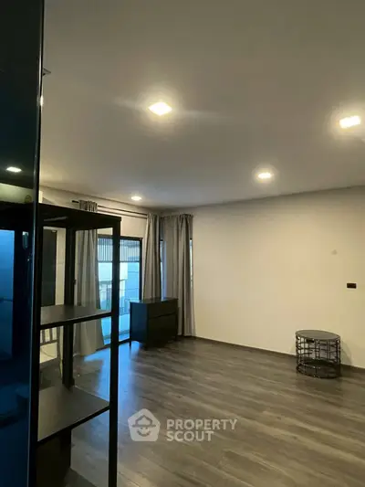 Spacious modern living room with sleek flooring and ample natural light