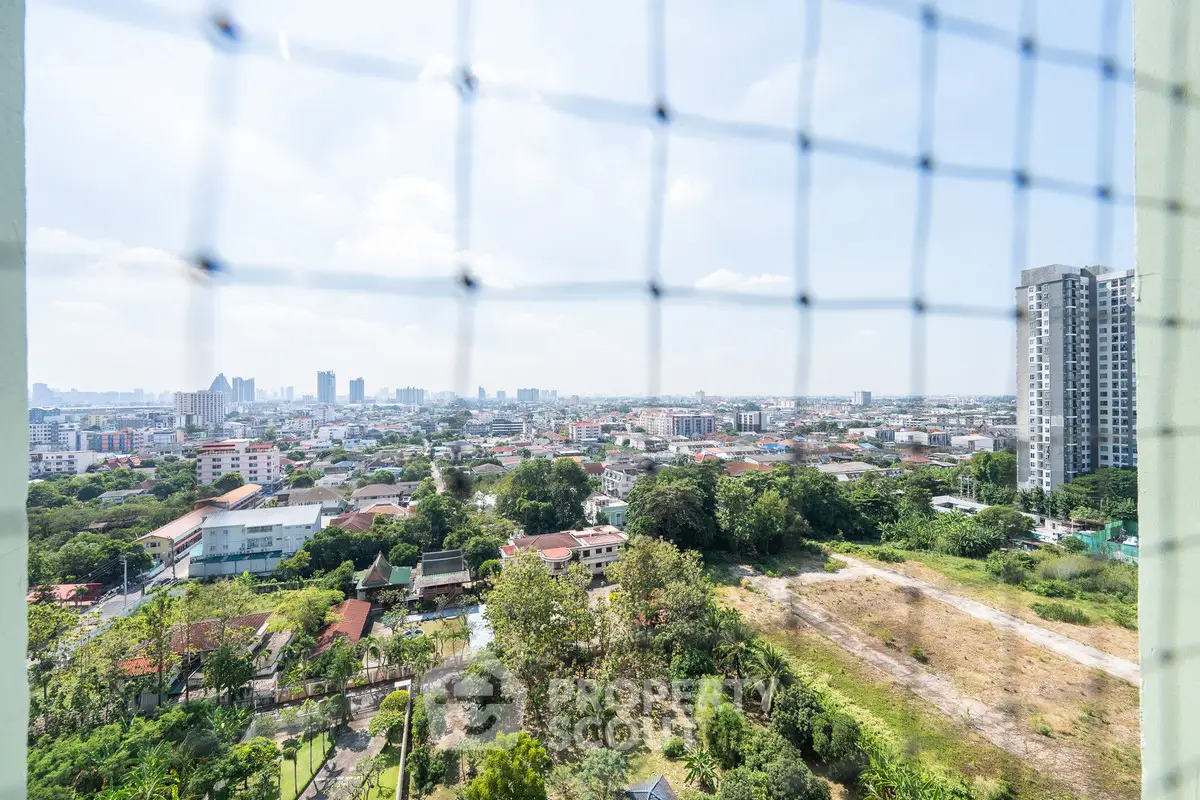 Stunning cityscape view from high-rise balcony with lush greenery and urban skyline.