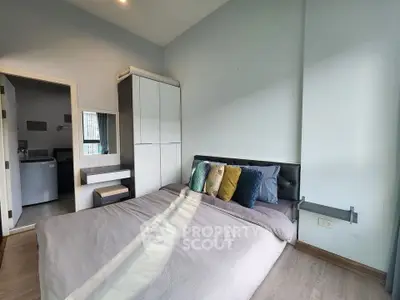 Modern bedroom with stylish decor and ample natural light, featuring a cozy bed and sleek wardrobe.