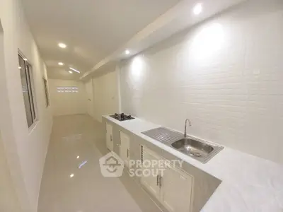 Modern kitchen with sleek white cabinets and gas stove in a spacious open layout.