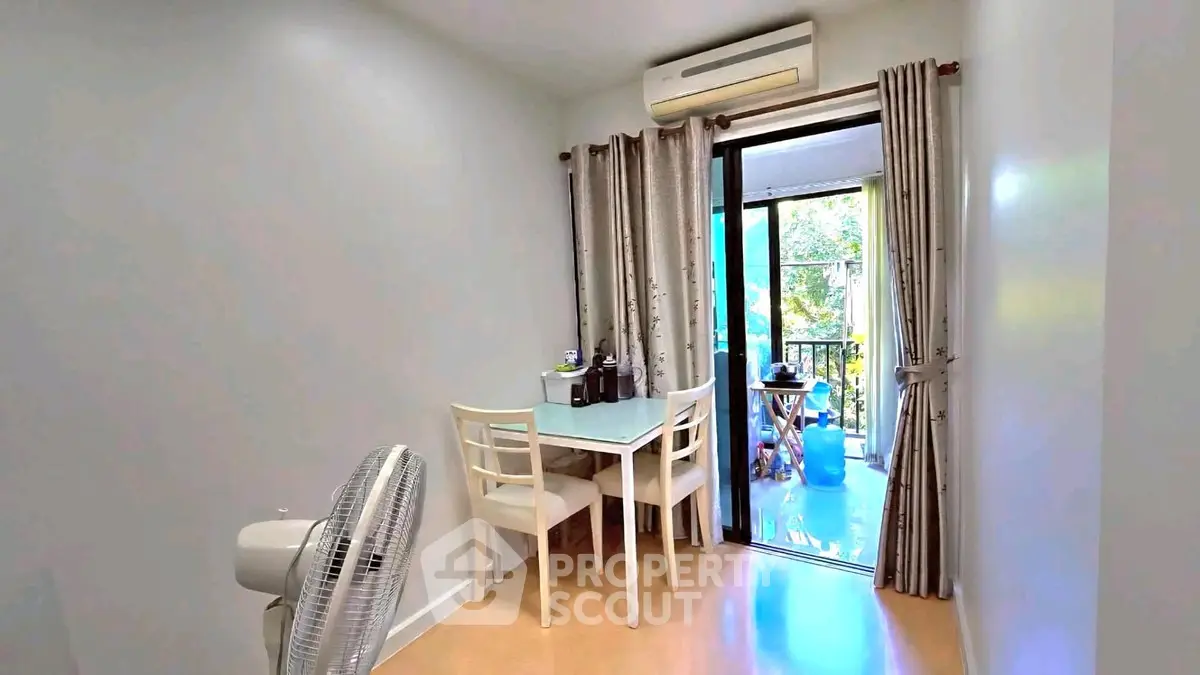 Charming dining area with balcony access and air conditioning, perfect for cozy meals.