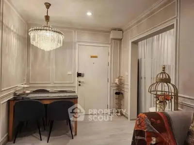Elegant living room with chandelier and modern decor, featuring a cozy dining area and stylish furnishings.