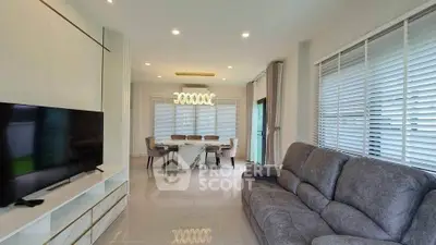 Modern living room with sleek furniture and elegant dining area, featuring large windows and stylish lighting.