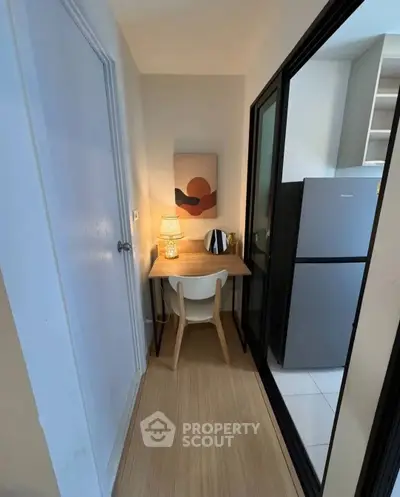 Cozy study nook with modern decor adjacent to a sleek kitchen area.