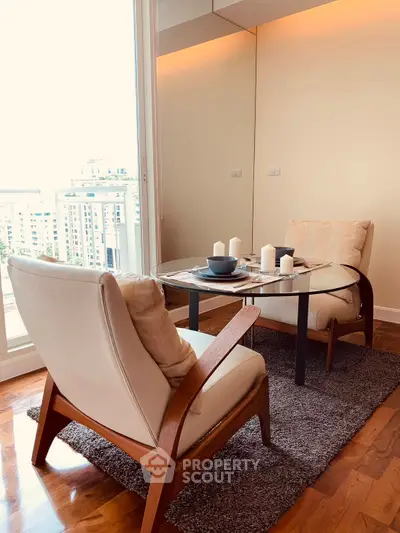 Chic modern living room with stylish armchairs and glass table, offering a stunning city view.