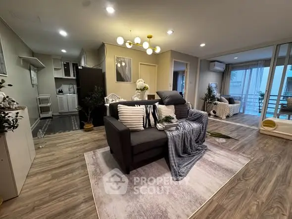 Spacious modern living room with elegant decor and open layout, featuring cozy seating and stylish lighting.