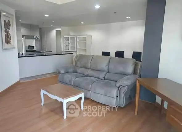 Spacious living room with modern furniture and open kitchen layout in a stylish apartment.