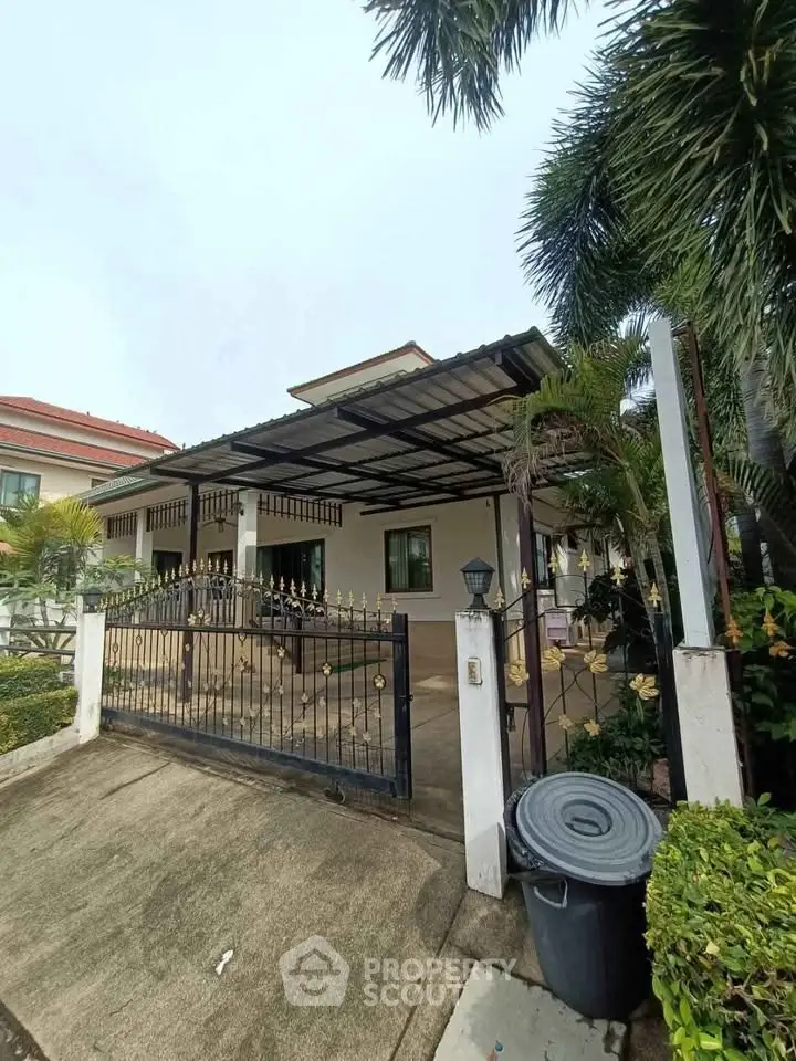 Charming single-story home with gated entrance and lush greenery, perfect for serene living.