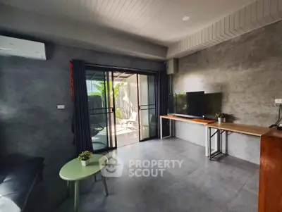 Modern living room with sleek design and outdoor access, featuring a TV and stylish decor.