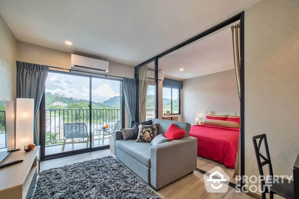 Modern condo with open living room and bedroom, featuring a balcony with scenic views.