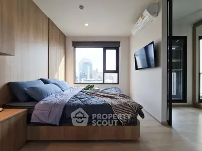 Modern bedroom with city view, featuring stylish decor and natural light.