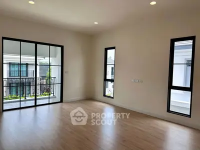 Spacious empty room with large windows and balcony view in modern home