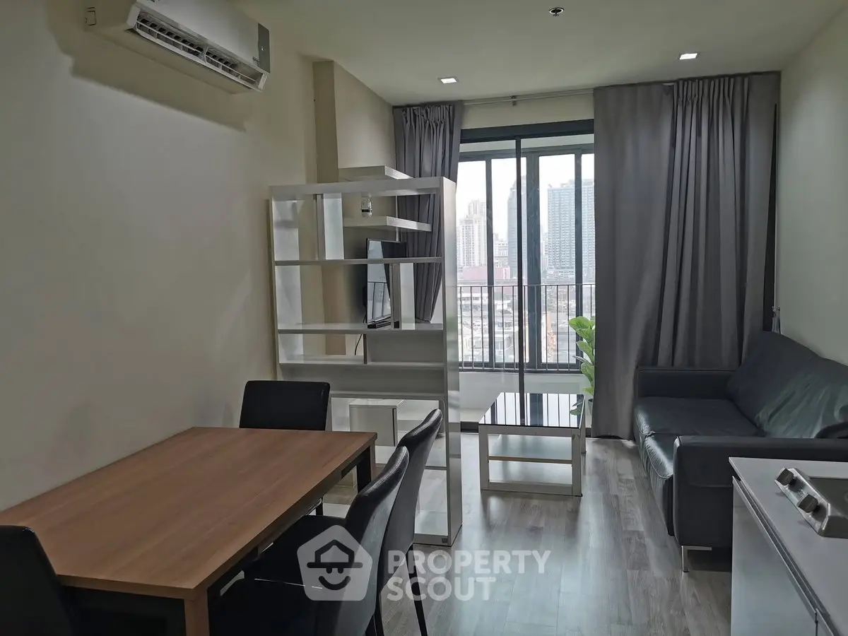 Modern living room with city view, featuring sleek furniture and large windows for natural light.