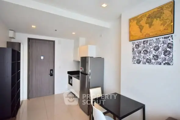 Modern apartment interior with compact kitchen and dining area, featuring stylish decor.
