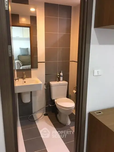Modern bathroom with sleek design and neutral tiles in a contemporary apartment.