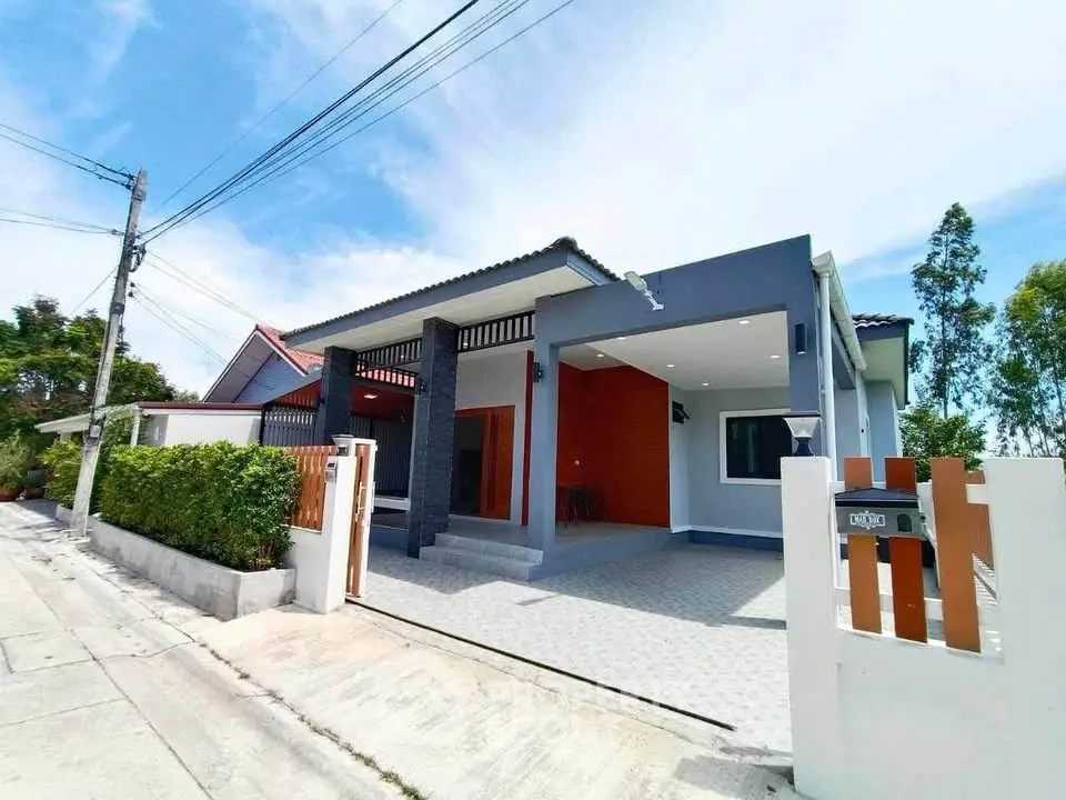 Modern single-story house with sleek design and spacious driveway in a serene neighborhood.