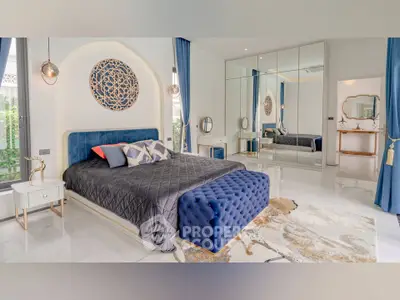 Luxurious bedroom with elegant decor, mirrored wardrobe, and plush blue accents for a sophisticated ambiance.