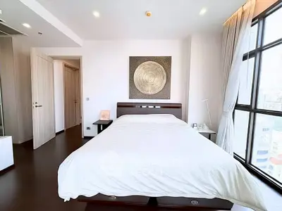 Spacious bedroom with modern decor and large windows offering city views.