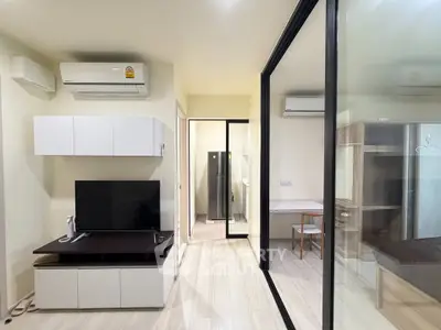 Modern living room with sleek design, featuring air conditioning and glass partition for a spacious feel.