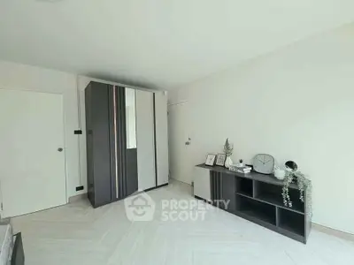 Spacious bedroom with modern wardrobe and sleek storage unit, perfect for stylish living.