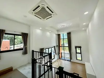 Spacious modern living room with high ceilings and large windows offering natural light and scenic views.