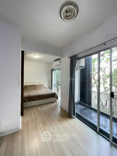 Cozy bedroom with balcony access and natural light in modern apartment