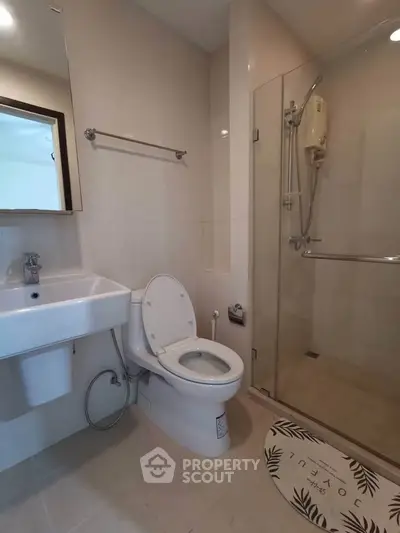 Modern bathroom with glass shower and sleek fixtures in a contemporary apartment.