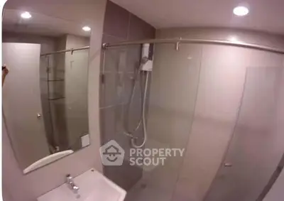 Modern bathroom with glass shower enclosure and sleek fixtures.