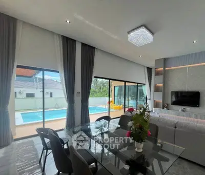 Luxurious living room with pool view, modern decor, and elegant dining area in a contemporary home.