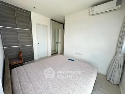 Spacious bedroom with modern design and ample natural light, featuring a sleek air conditioning unit.