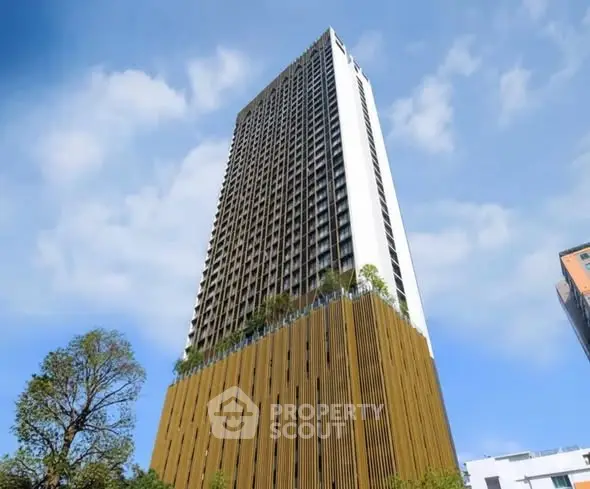 Stunning high-rise building with modern architectural design and lush greenery.