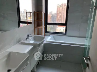 Modern bathroom with dual sinks and city view from large windows