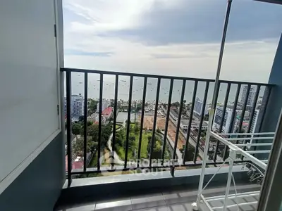 Stunning high-rise balcony view overlooking cityscape and ocean horizon, perfect for urban living.