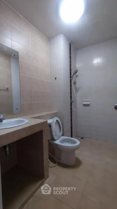 Spacious bathroom with modern fixtures and neutral tiles, ideal for comfort and functionality.