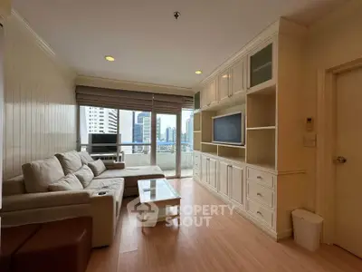 Spacious living room with city view, modern furniture, and built-in entertainment center.