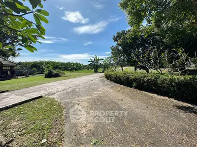 Expansive garden view with lush greenery and clear blue sky, perfect for nature lovers.