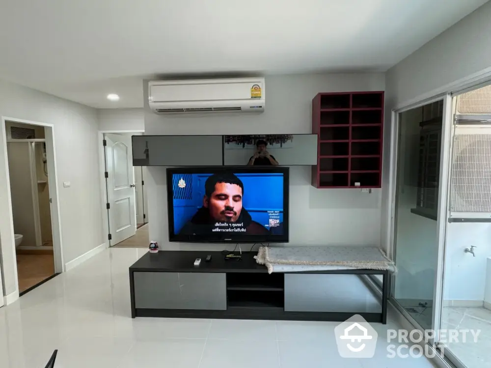 Modern living room with sleek TV setup and air conditioning unit