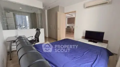 Modern bedroom with study area and sleek furnishings in a contemporary apartment.