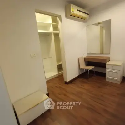 Spacious bedroom with walk-in closet and modern air conditioning unit.